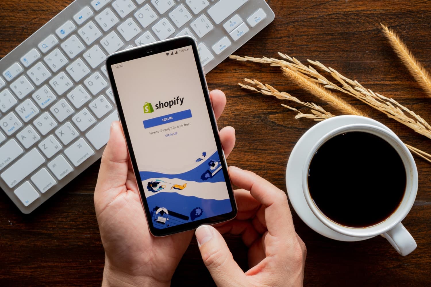 A man holding a cellphone which displays the Shopify login page on the screen